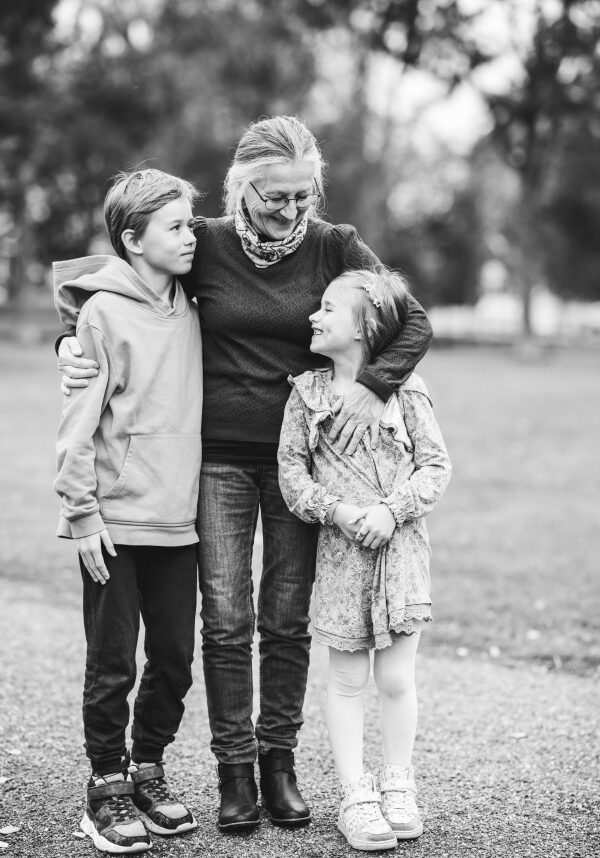 Familjefotografering i Umeå, en mormor eller farmor kramar om sina barnbarn